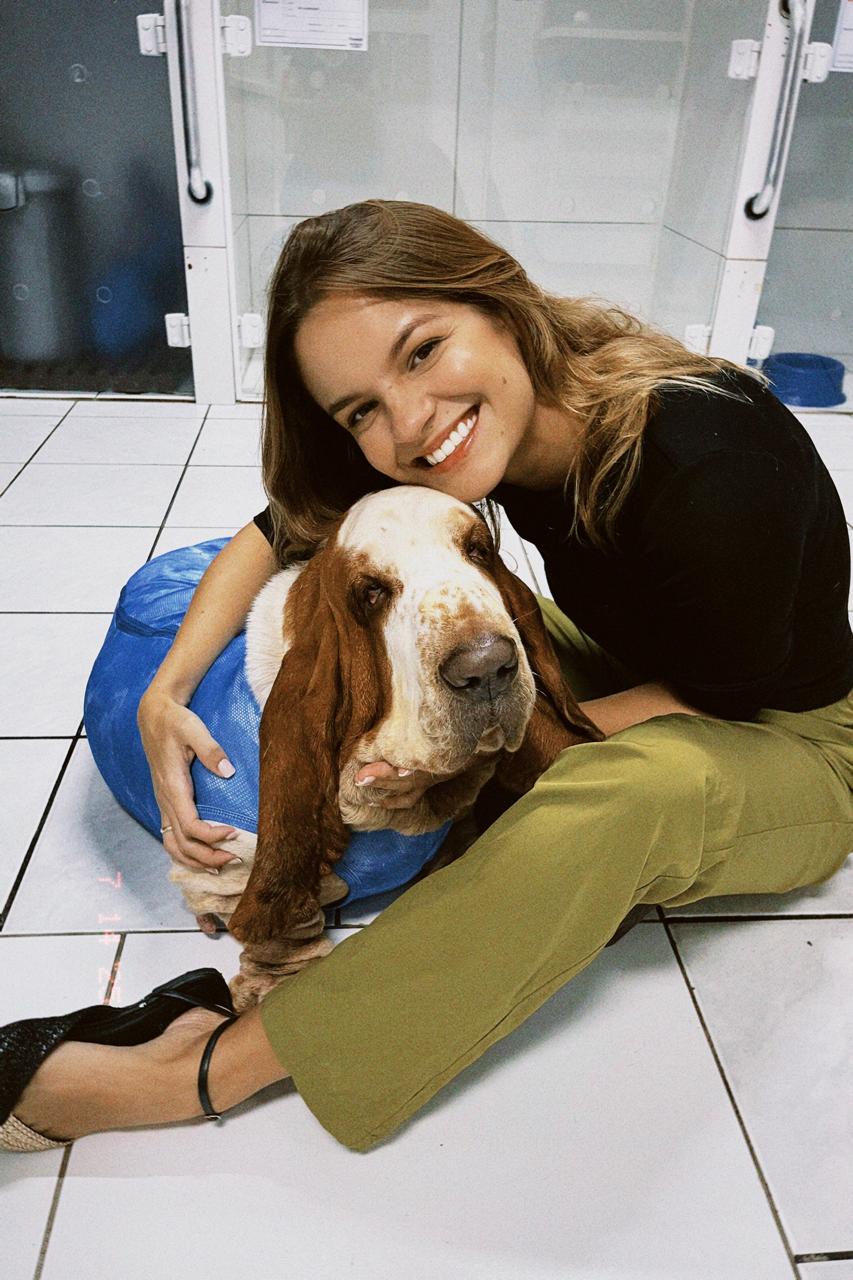 Cliente sorrindo com cachorro após atendimento