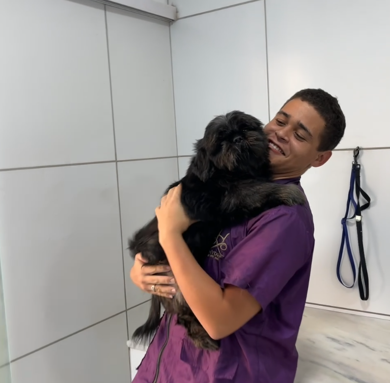 Profissional segurando um pet após banho e tosa